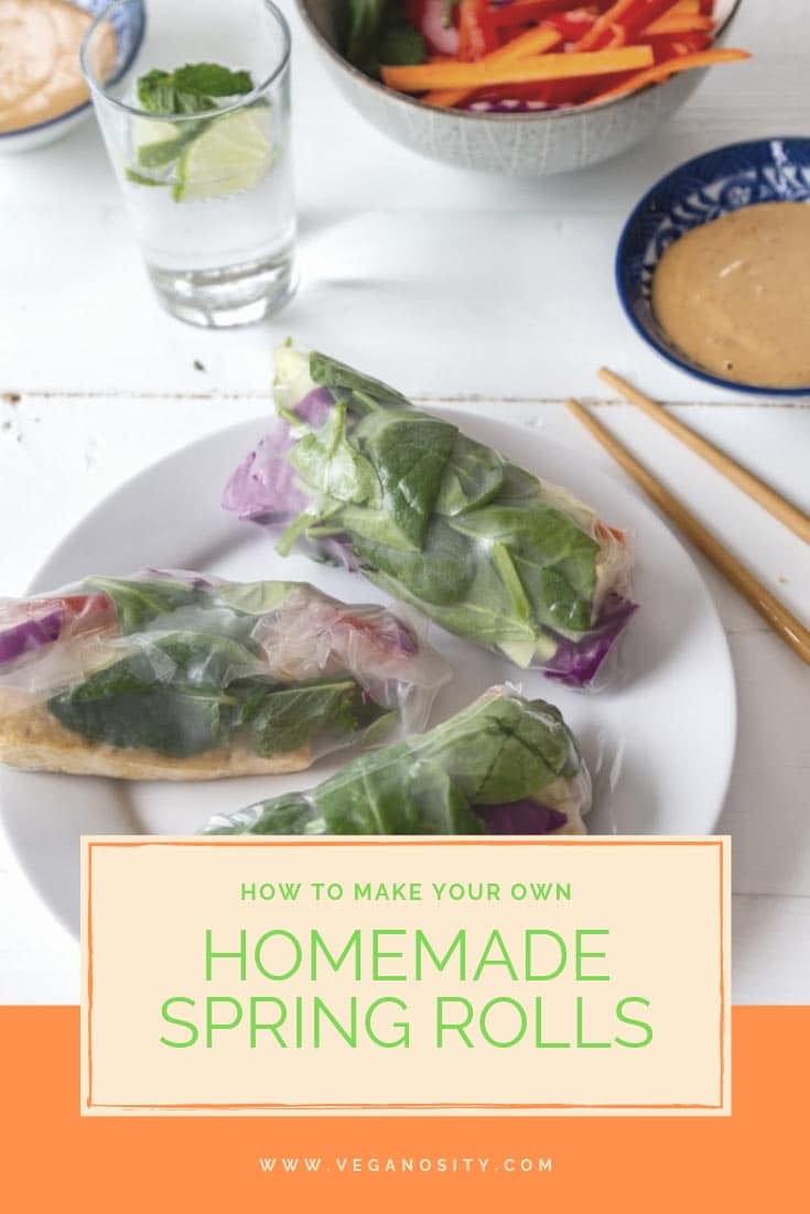 A Pinterest pin with a white plate of spring rolls on a white table with peanut sauce in a blue bowl and a glass of water and chopsticks. 