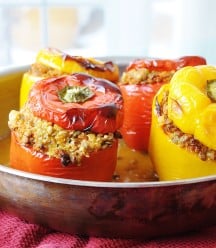 Vegan Lentil Quinoa and Vegetable Stuffed Peppers in a copper pan with the tops of the peppers on