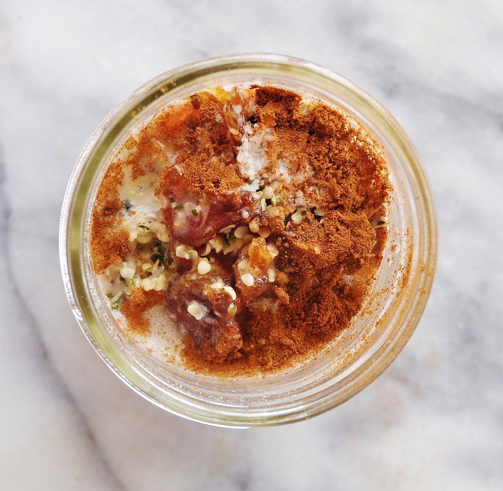 Vegan Carrot Cake Overnight Oats in a clear glass jar on a marble surface
