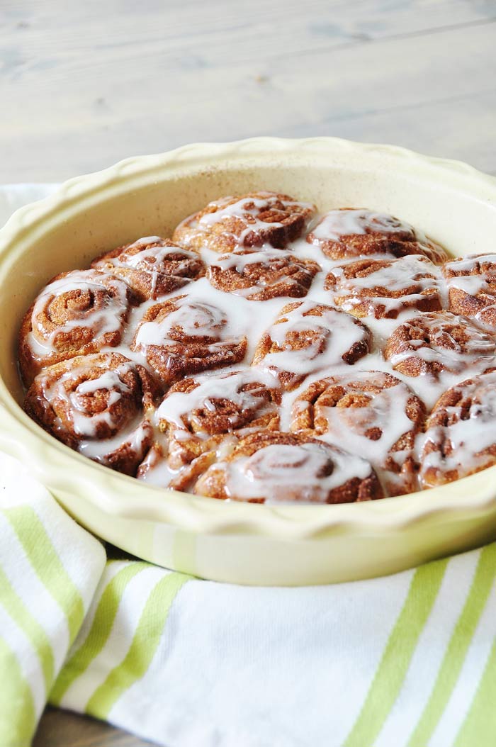 a pan of Homemade Vegan Cinnamon Rolls on a green and white striped towel