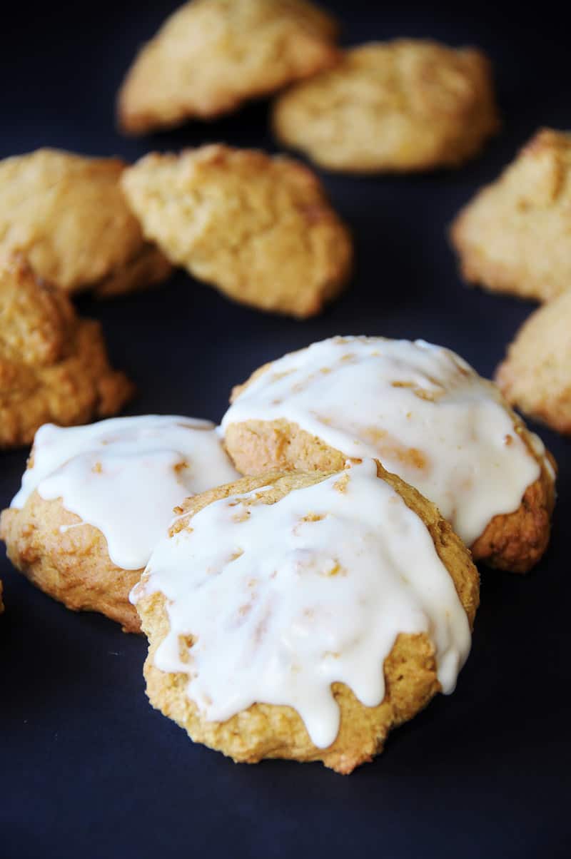 3 vegan pumpkin spice cookies frosted with a sugar glaze.