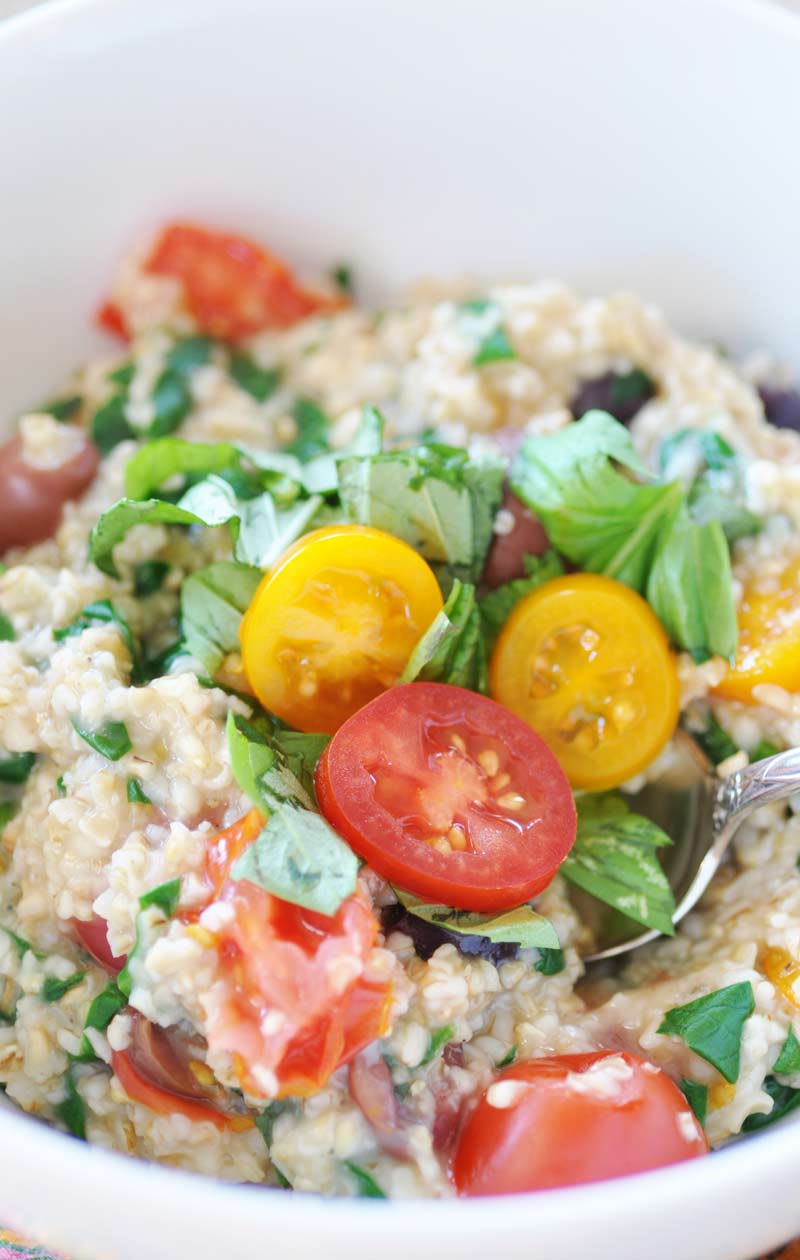 Savory vegan Mediterranean Oatmeal! This savory breakfast recipe is filled with spinach, tomatoes, Kalamata olives, basil, and steel cut oats. A delicious way to enjoy your oatmeal. This is one of my favorites! www.veganosity.com