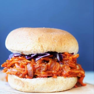 Pulled BBQ-Carrots with Homemade BBQ Sauce Sandwich on a wood board with shredded red cabbage