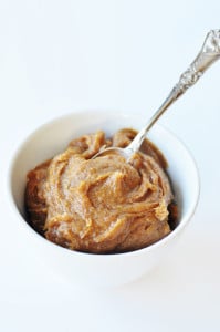 Date caramel in a white bowl with a silver spoon stuck in the center