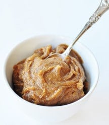 Date caramel in a white bowl with a silver spoon stuck in the center