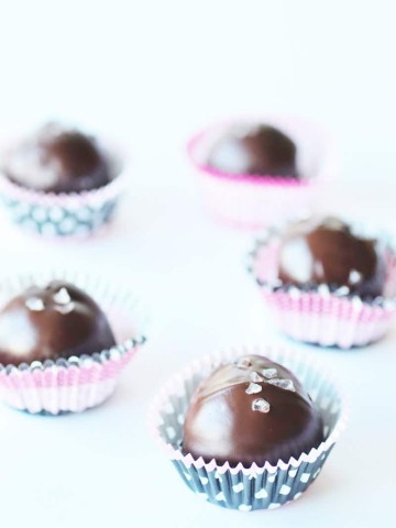 5 Ingredient Vegan Turtle Truffles (Raw & Gluten-free)in pink cupcake liners on a white background