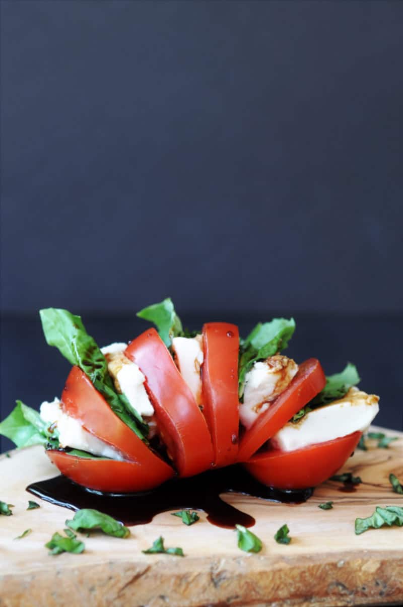 Single Serving Vegan Caprese Salad! This delicious and simple recipe makes the perfect lunch or appetizer for one. All you need is a tomato, some vegan mozzarella, basil, and balsamic vinegar. www.veganosity.com