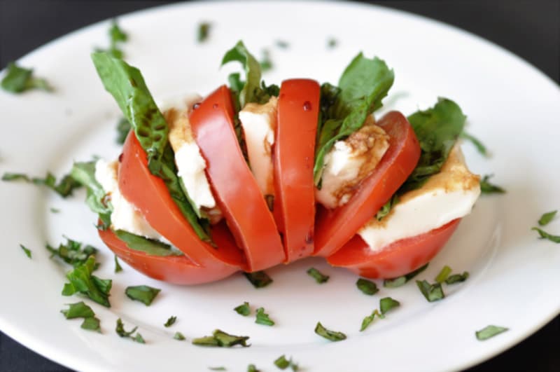 Single Serving Vegan Caprese Salad! This delicious and simple recipe makes the perfect lunch or appetizer for one. All you need is a tomato, some vegan mozzarella, basil, and balsamic vinegar. www.veganosity.com