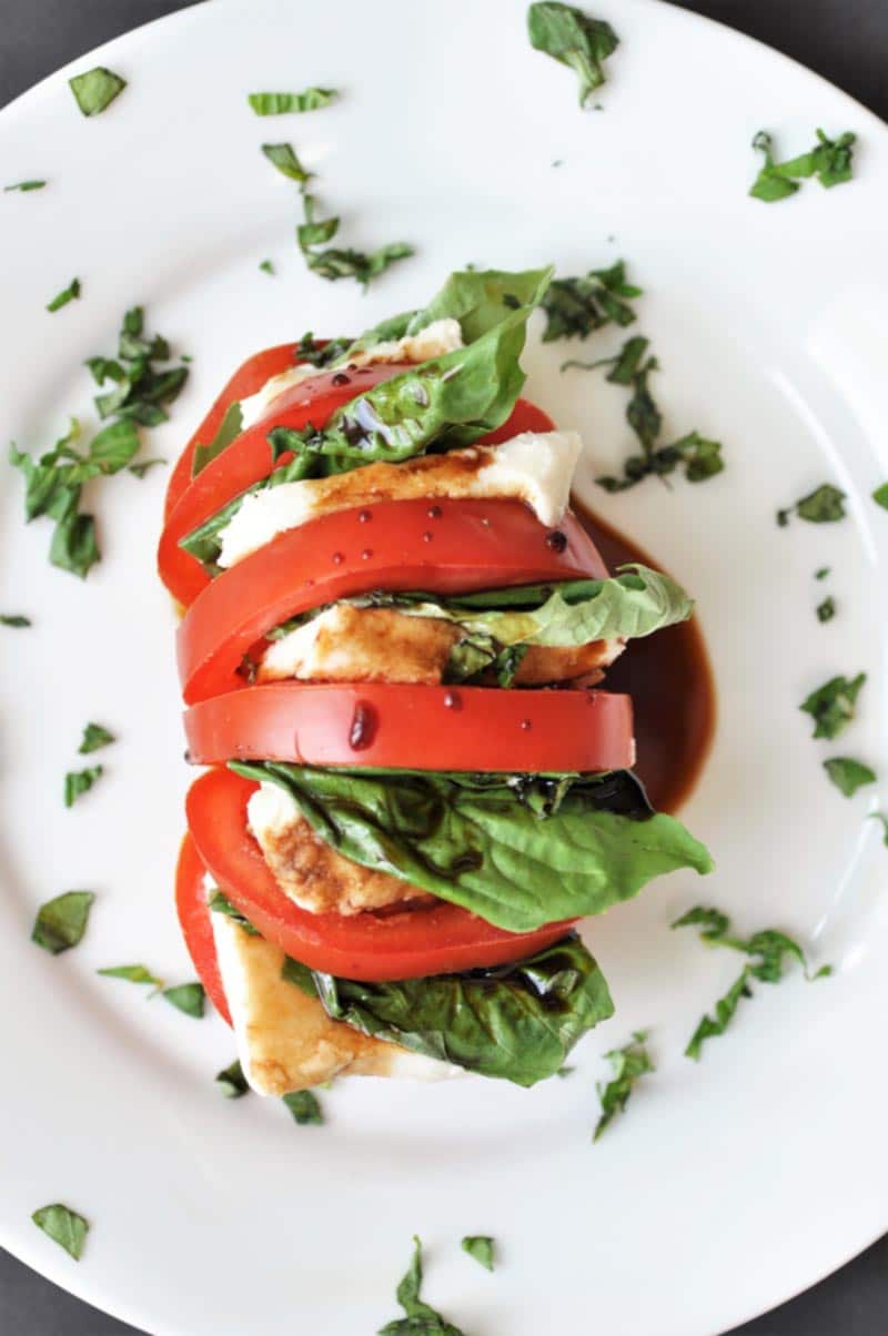 Single Serving Vegan Caprese Salad! This delicious and simple recipe makes the perfect lunch or appetizer for one. All you need is a tomato, some vegan mozzarella, basil, and balsamic vinegar. www.veganosity.com