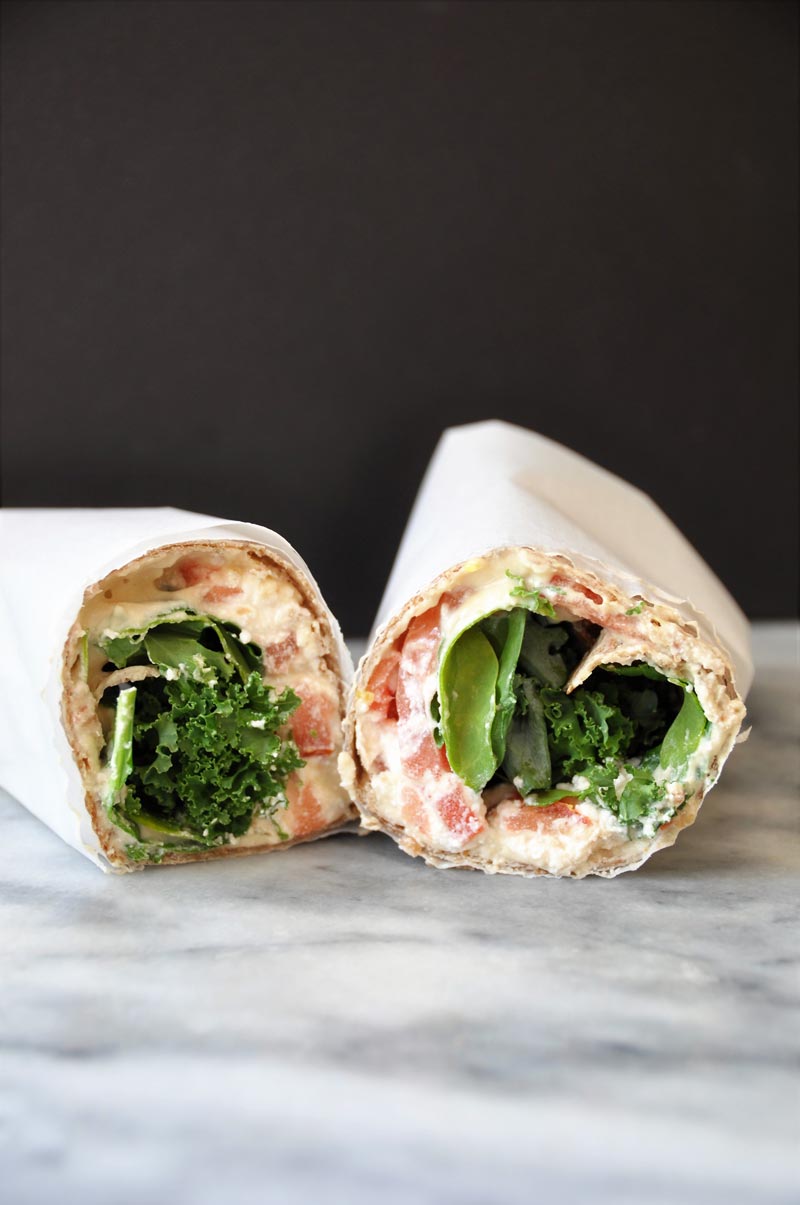 A ridiculously easy wrap stuffed with hummus, vegan ricotta cheese, kale, spinach, and tomato! Take it to work or school, or slice it into rolls for appetizers! www.veganosity.com