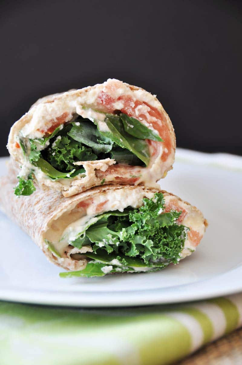 A ridiculously easy wrap stuffed with hummus, vegan ricotta cheese, kale, spinach, and tomato! Take it to work or school, or slice it into rolls for appetizers! www.veganosity.com
