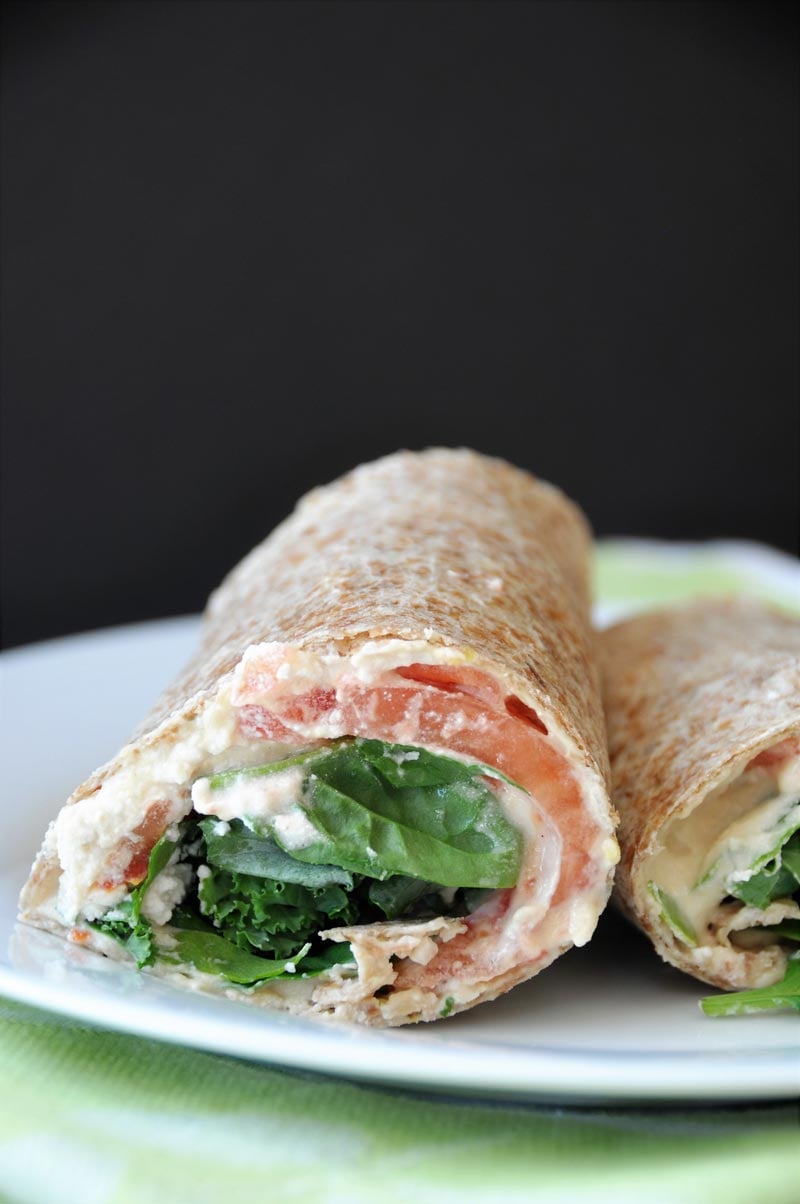 A ridiculously easy wrap stuffed with hummus, vegan ricotta cheese, kale, spinach, and tomato! Take it to work or school, or slice it into rolls for appetizers! www.veganosity.com
