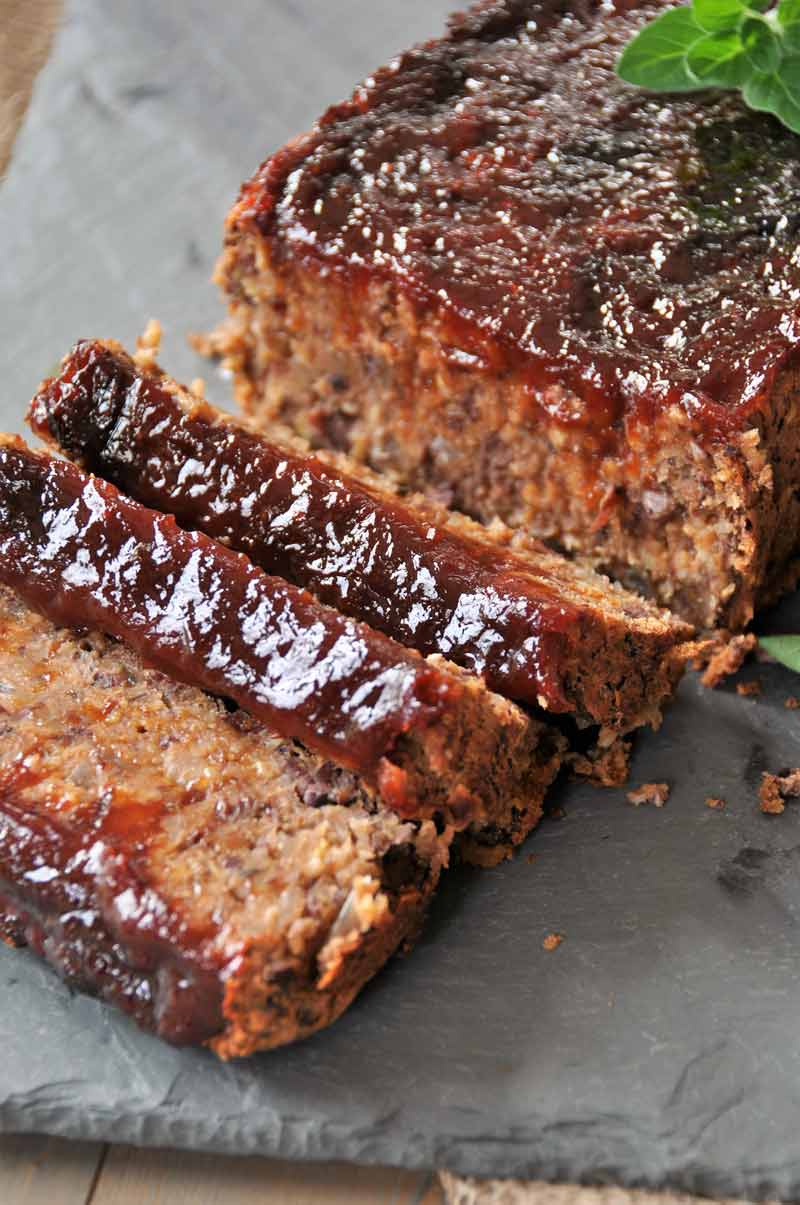 A close up shot of sliced Vegan meatloaf on a piece of slate.