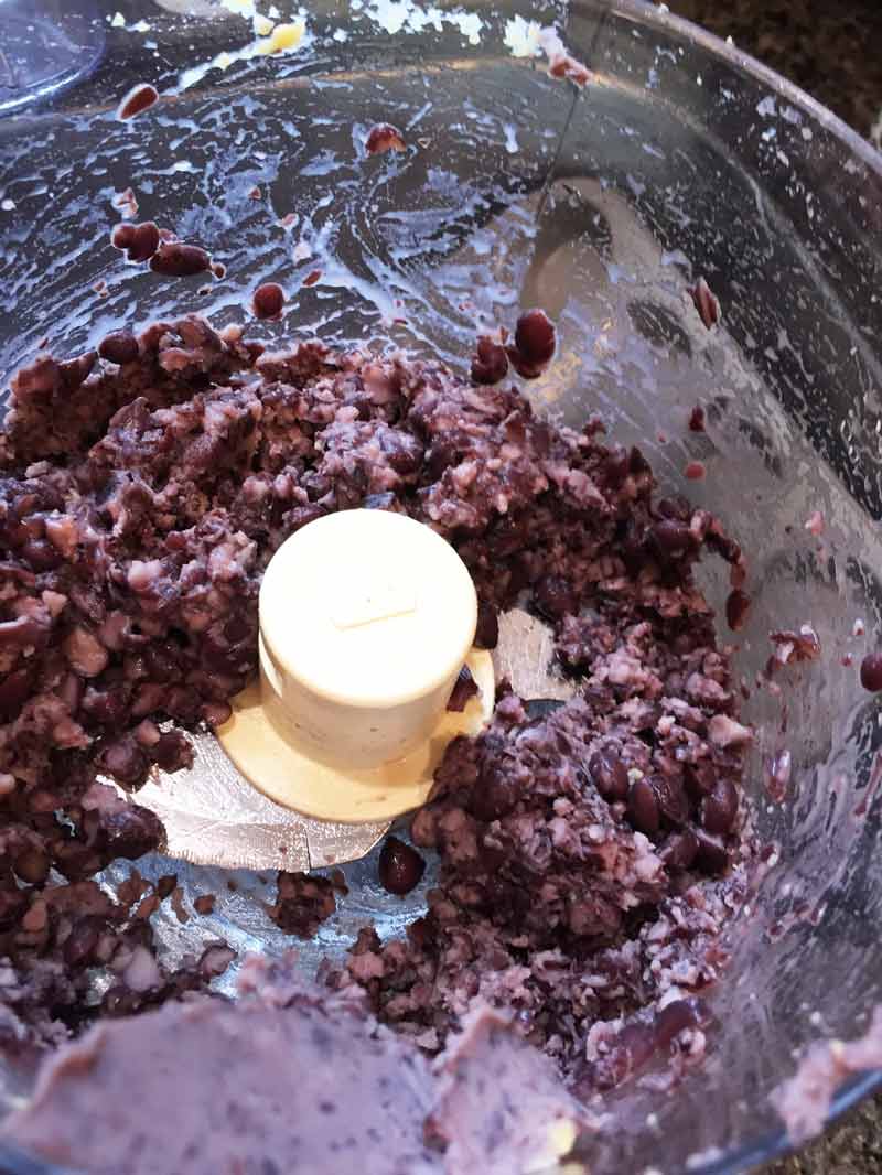 Partially ground black beans in a food processor