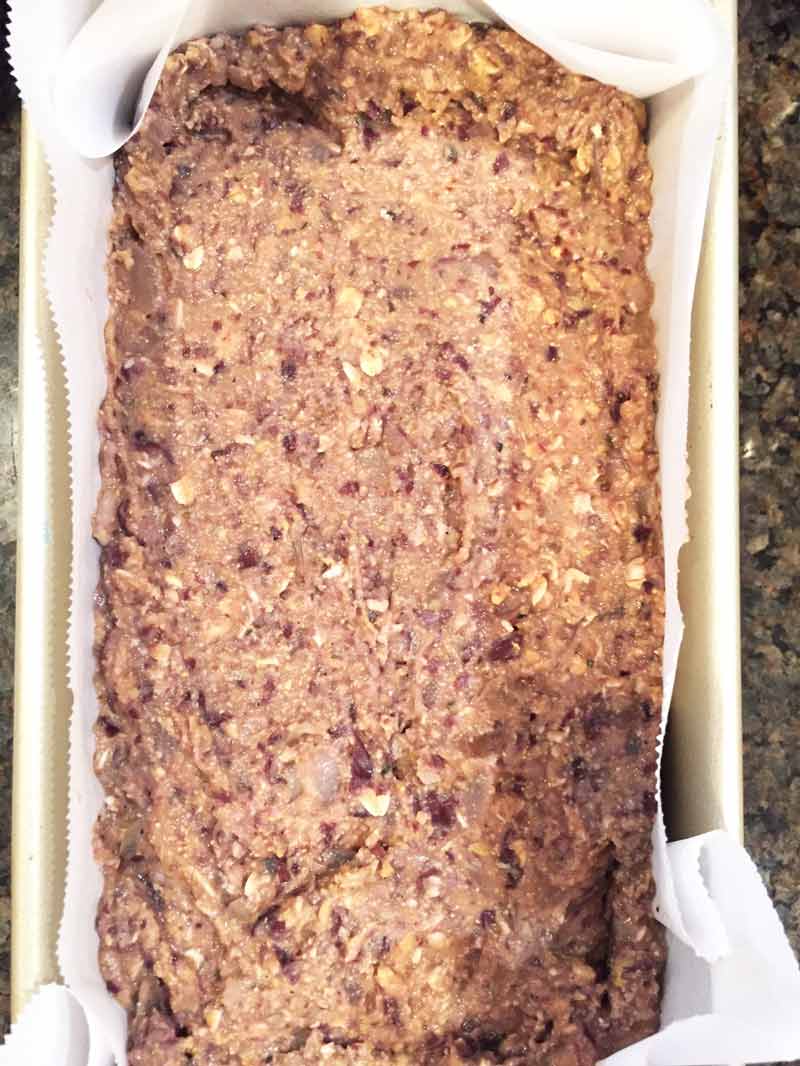 uncooked vegan meatloaf in a bread pan with parchment paper