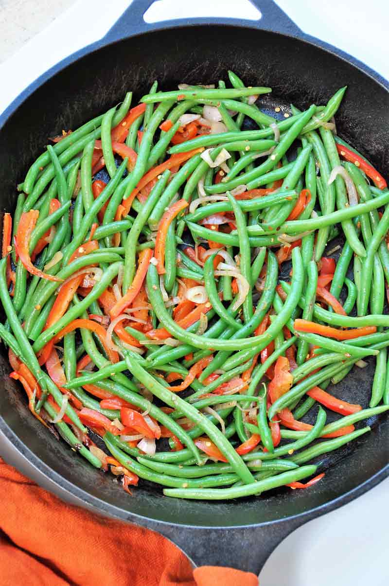 Green beans and red pepper in an iron skillet.
