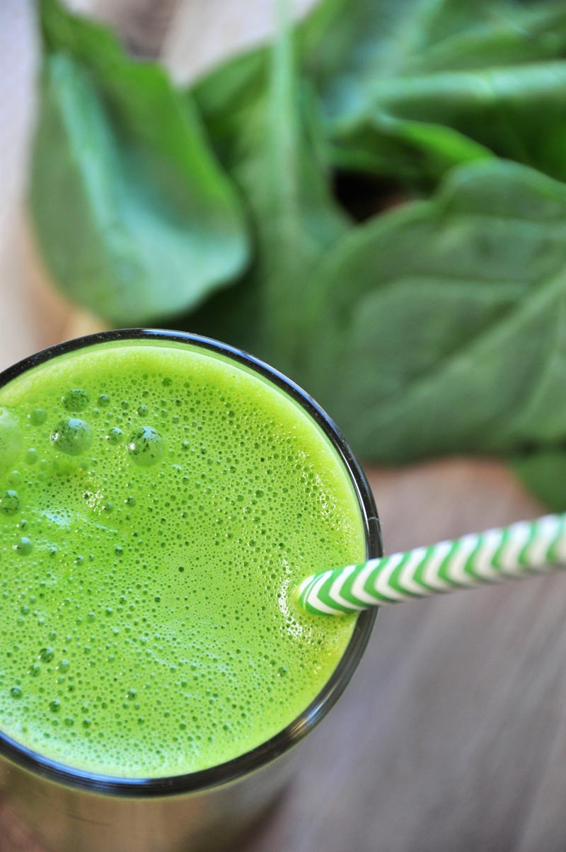 5 ingredient homemade green juice with spinach, apple, lemon, and turmeric. A healthy and tasty way to drink your veggies.