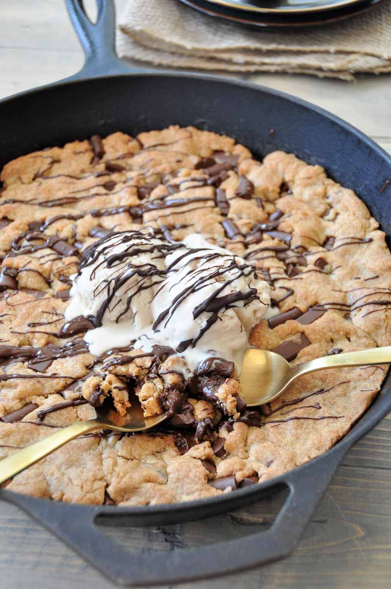 One big vegan chocolate chip cookie in an iron skillet! The perfect dessert for a party. Dairy and egg-free.