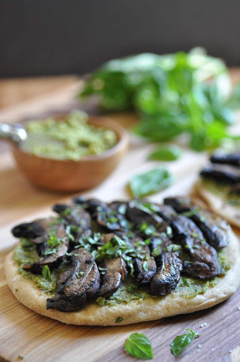 Mushroom flatbread pizza on a wooden board.