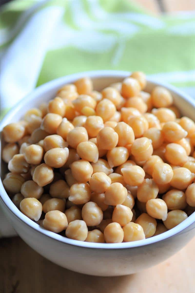 A white bowl filled with cooked chickpeas. 