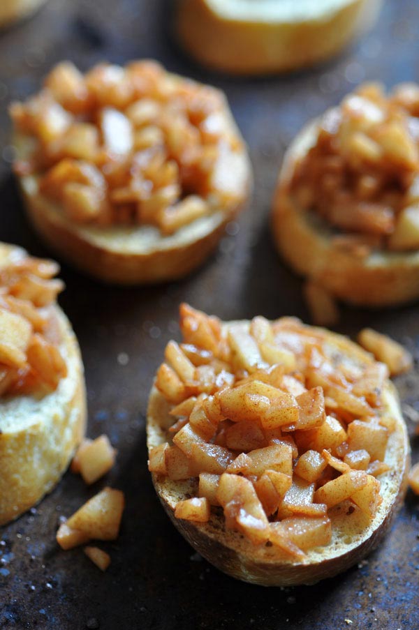 Cinnamon toast with baked apples on top on a baking sheet