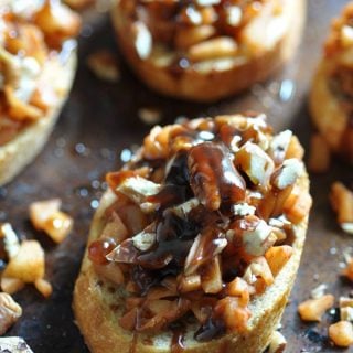 Apple Cinnamon Bruschetta on a baking sheet with chopped pecans scattered around the pan