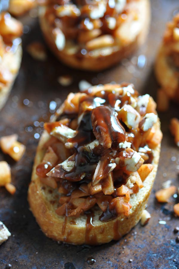 Savory and sweet apple cinnamon bruschetta drizzled with vegan caramel sauce on a baking sheet