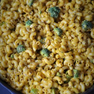 A cast-iron skillet filled with black pepper cheesy mac and brocolli