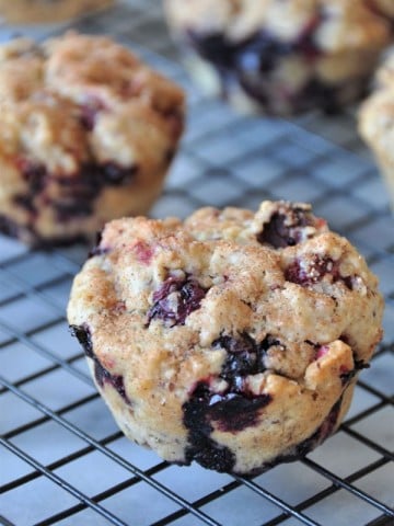 Vegan cranberry blueberry muffins cooling on a wire rack