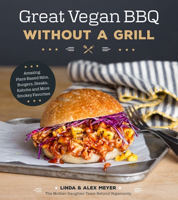 Cover of Great Vegan BBQ Without a Grill with a Shredded jackfruit and grilled pineapple BBQ sandwich with red cabbage on parchment and a silver tray with a silver fork and a blue and white striped napkin