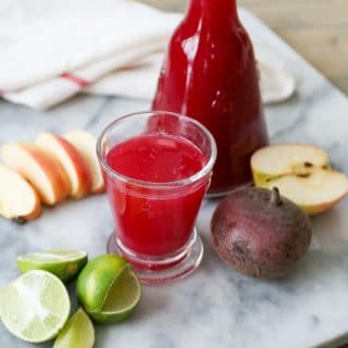 Beet Juice with glass, limes, beets, and apples