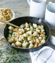 Potatoes in skillet with vegan parmesan, chives, and truffle oil