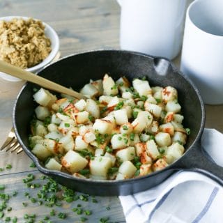 Potatoes in skillet with vegan parmesan, chives, and truffle oil