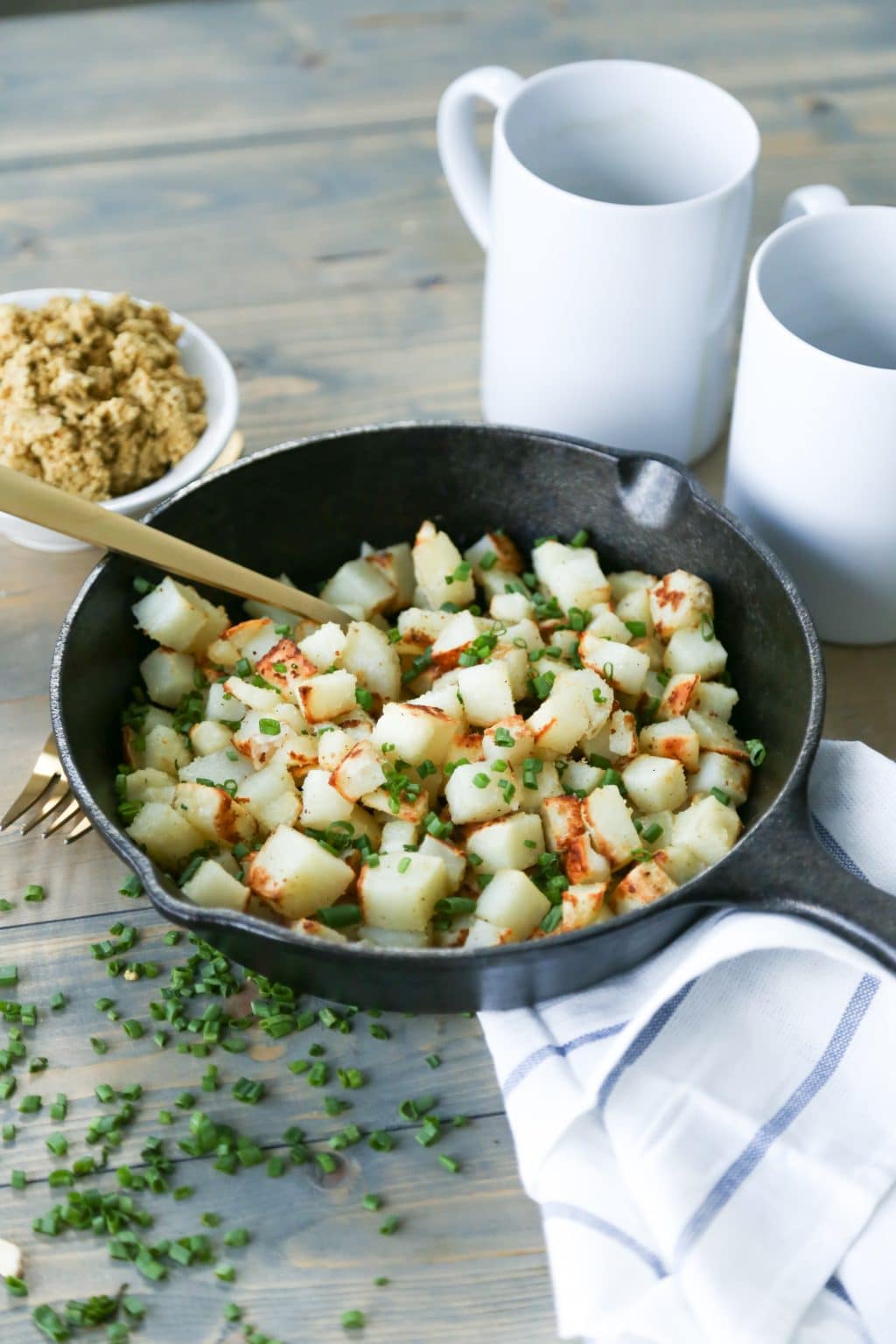 Potatoes in skillet with vegan parmesan, chives, and truffle oil