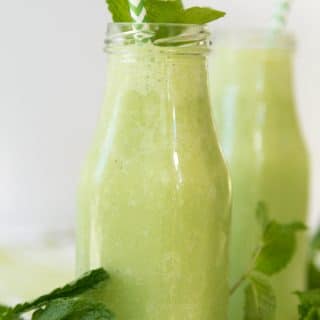 Shamrock shakes in front of a white background with mint and green and white straws