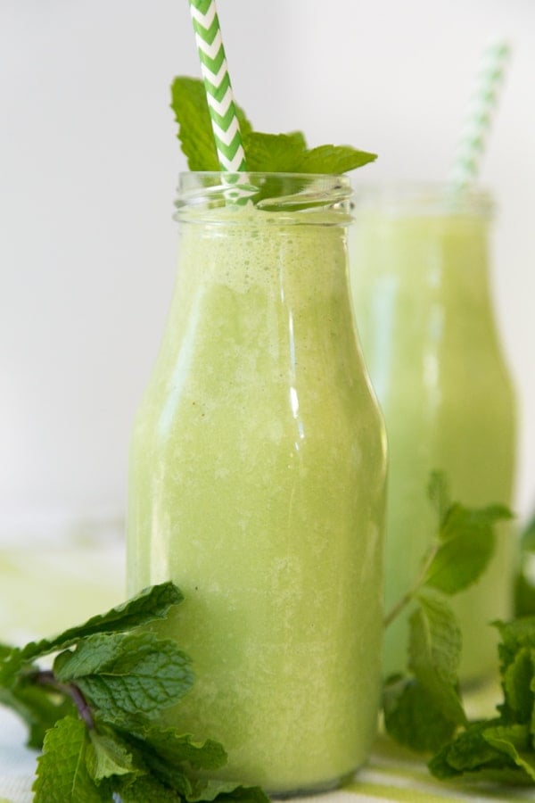 Shamrock shakes in front of a white background with mint and green and white straws