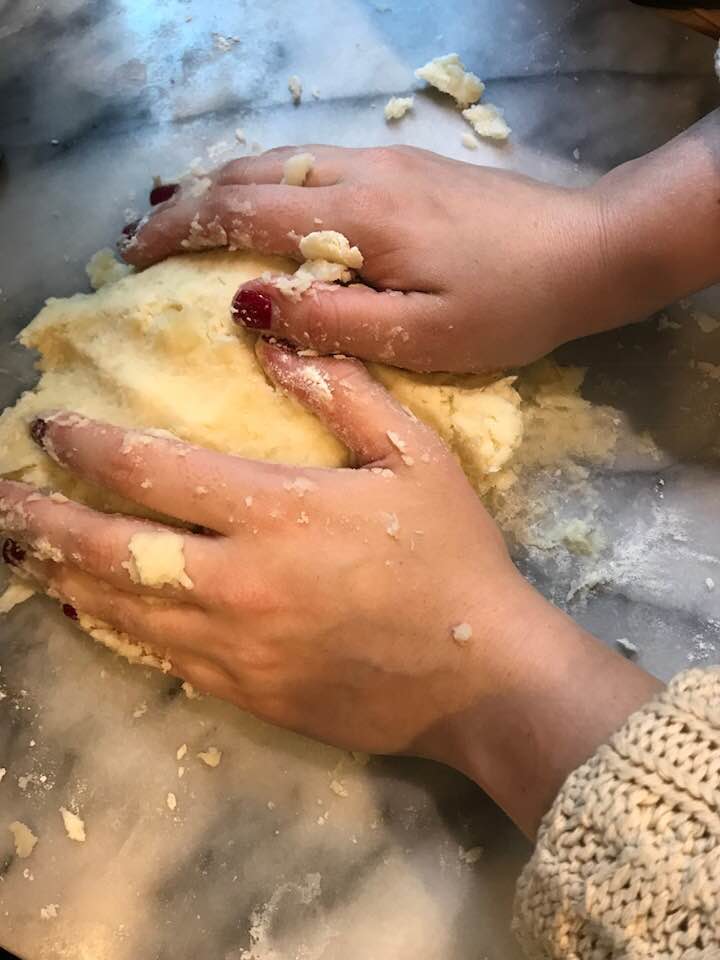 kneading the dough to make homemade gnocchi on a marble surface