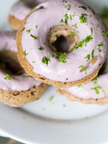 Donuts on a white plate with pink frosting and lime zest