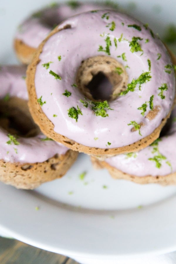 Donuts on a white plate with pink frosting and lime zest