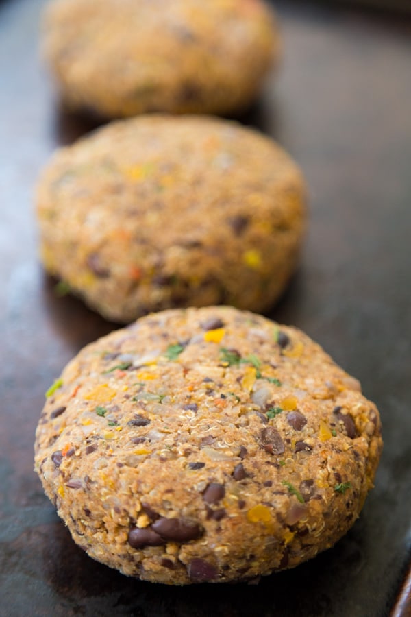 uncooked black bean patties in a row on a baking sheet