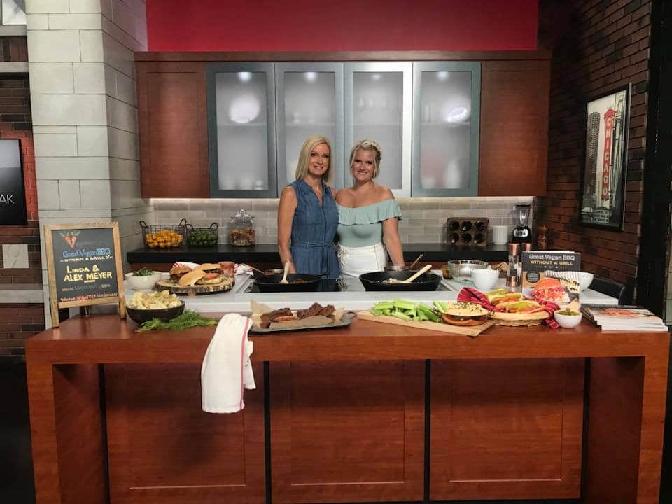 Linda and Alex at WGN News studios in front of the recipes they made for the Veganosity Cookbook; Great Vegan BBQ Without a Grill