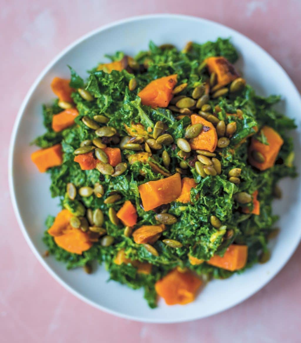 Avocado Kale Salad with Butternut Squash on a blue dish with a pink background