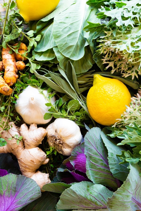 Lemons, garlic, ginger, turmeric, and herbs on a board