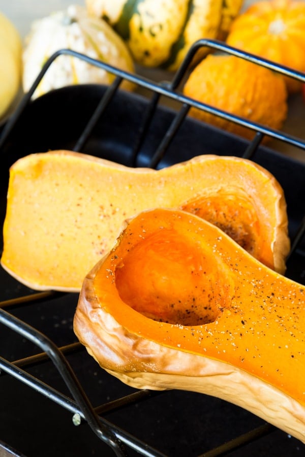 Roasted butternut squash with salt and pepper on a roasting tray