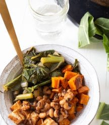 A bowl of BBQ vegetables in a white bowl with a gold fork sticking out of the bowl