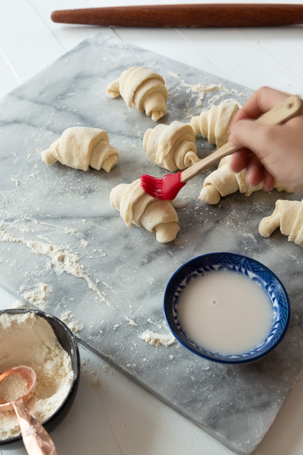 croissants being brushed with almond milk 