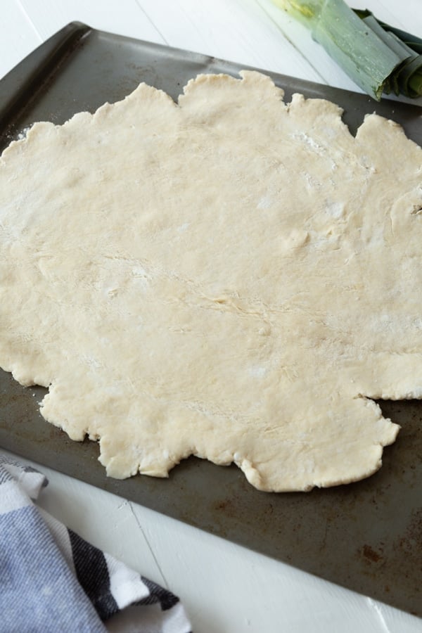 Homemade vegan pie crust rolled out on a baking sheet 