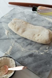 vegan croissant dough rolled out into long rectangle over marble