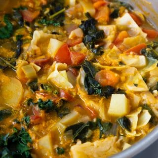 A pot of cabbage soup on a white table