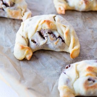Five empandas on a cookie sheet with parchment paper